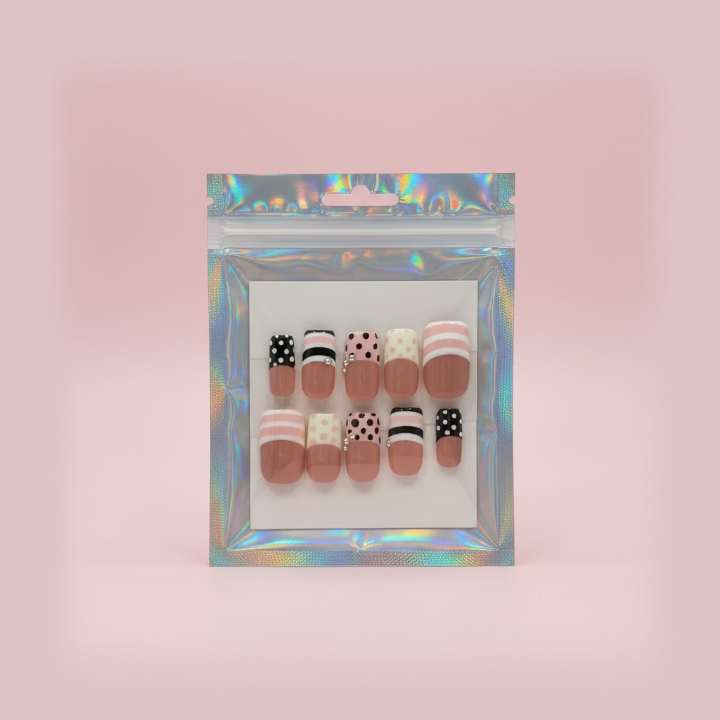 A packaged set of nail art designs on a wooden surface with a cup and other items in the background.