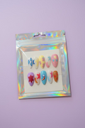 Packaged colorful nail art designs on a wooden surface